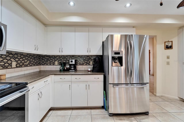 kitchen featuring decorative backsplash, white cabinetry, appliances with stainless steel finishes, and dark stone counters