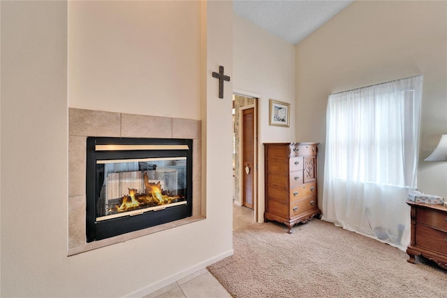 bedroom featuring a multi sided fireplace, light carpet, and lofted ceiling