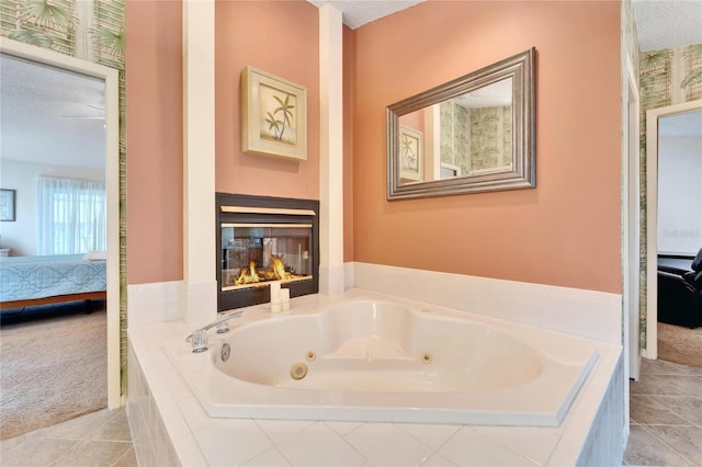 bathroom with tile patterned floors, a relaxing tiled tub, and a textured ceiling