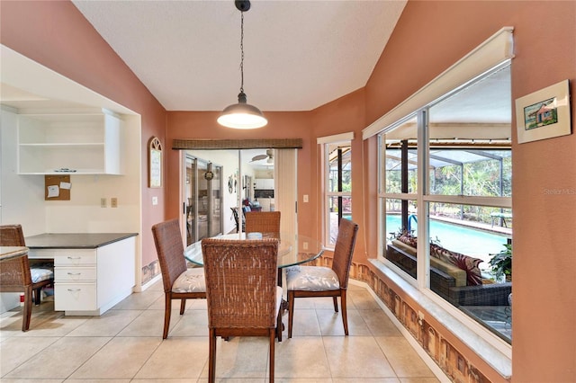 tiled dining room with lofted ceiling