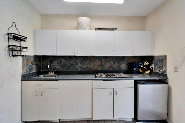 kitchen with white cabinets, backsplash, fridge, and sink