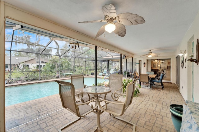 sunroom with a pool and ceiling fan