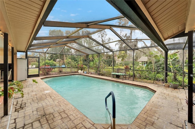 view of swimming pool featuring glass enclosure and a patio area