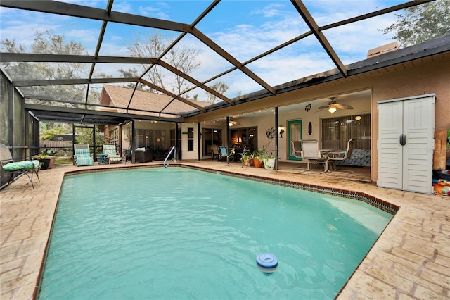 view of swimming pool featuring ceiling fan, a patio area, and glass enclosure