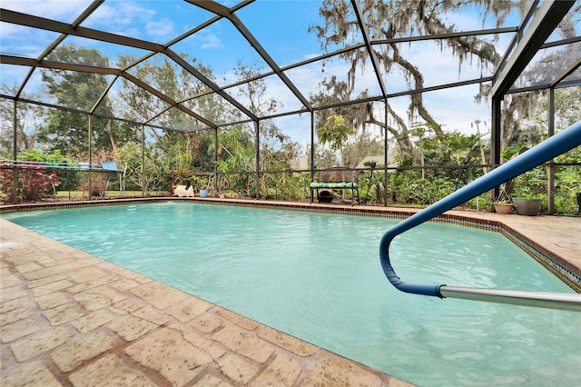 view of pool with glass enclosure and a patio area