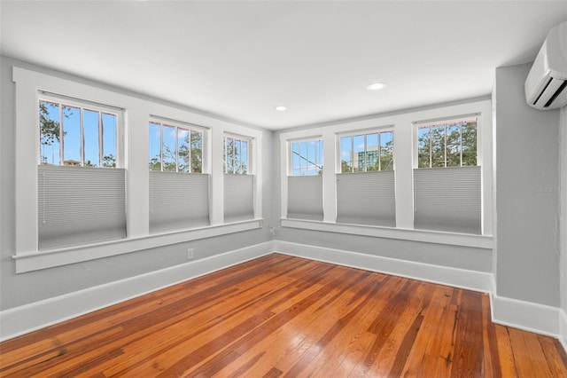 unfurnished sunroom with a wall mounted air conditioner