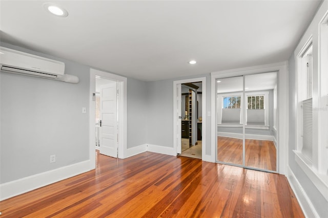 interior space featuring wood-type flooring and a wall mounted AC