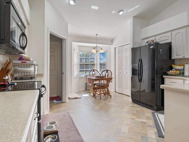 kitchen featuring white cabinetry, a chandelier, black appliances, and hanging light fixtures