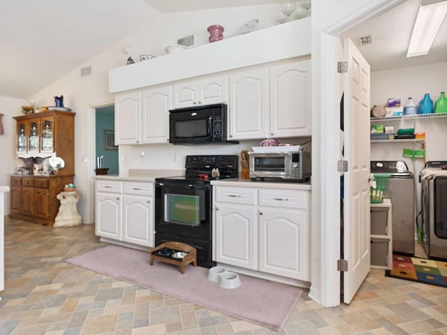 kitchen with washer and dryer, vaulted ceiling, white cabinetry, and black appliances