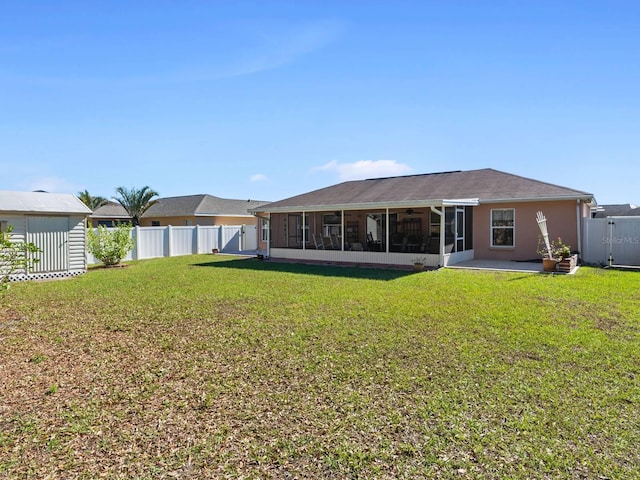 rear view of property featuring a yard and a sunroom