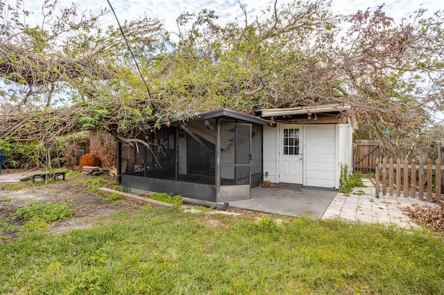 view of outdoor structure featuring a yard and a sunroom