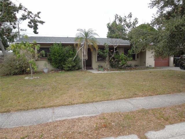 view of front of home with a front yard and a garage