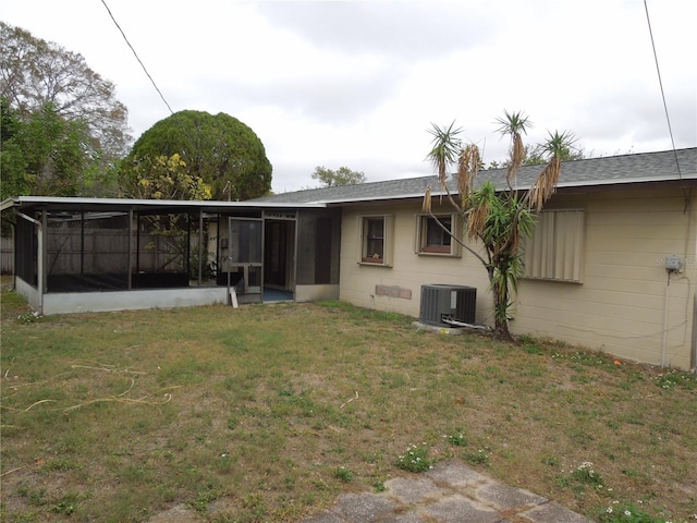 rear view of property featuring central AC, a yard, and a sunroom