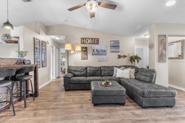 living room with vaulted ceiling, hardwood / wood-style flooring, and ceiling fan