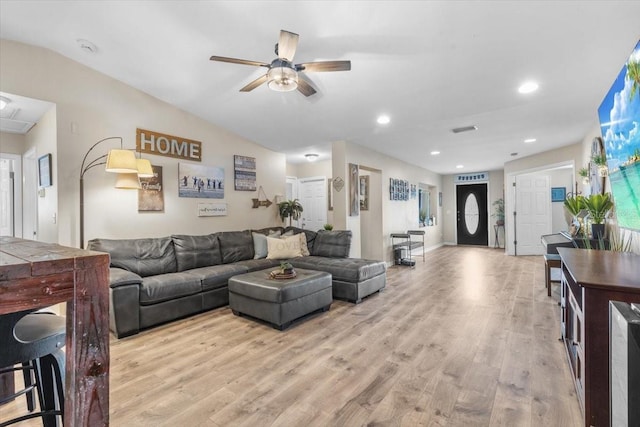 living room with ceiling fan, light hardwood / wood-style flooring, and lofted ceiling