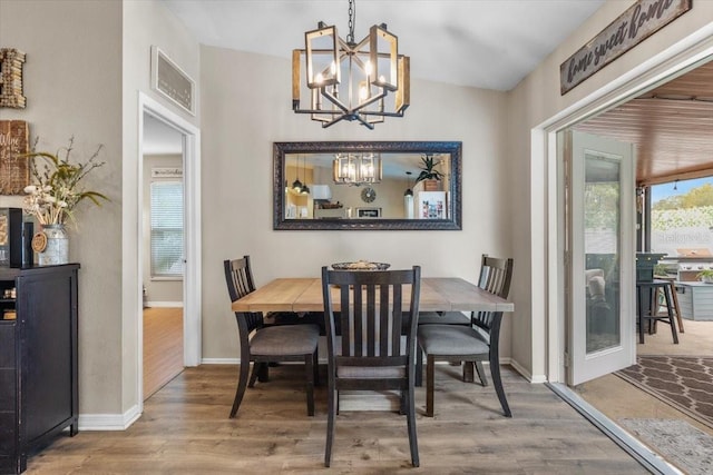 dining area featuring an inviting chandelier and wood-type flooring