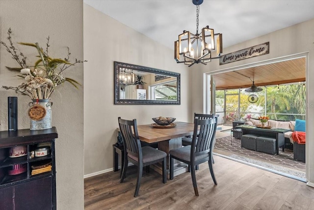 dining area with hardwood / wood-style floors and an inviting chandelier