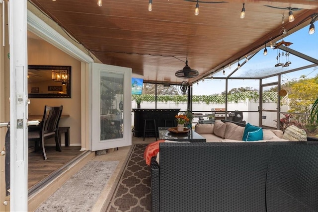 sunroom with track lighting, wooden ceiling, and a healthy amount of sunlight