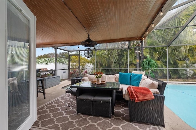 view of patio featuring ceiling fan, glass enclosure, and outdoor lounge area