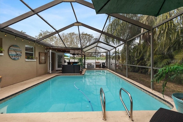 view of pool with a patio area, glass enclosure, and outdoor lounge area