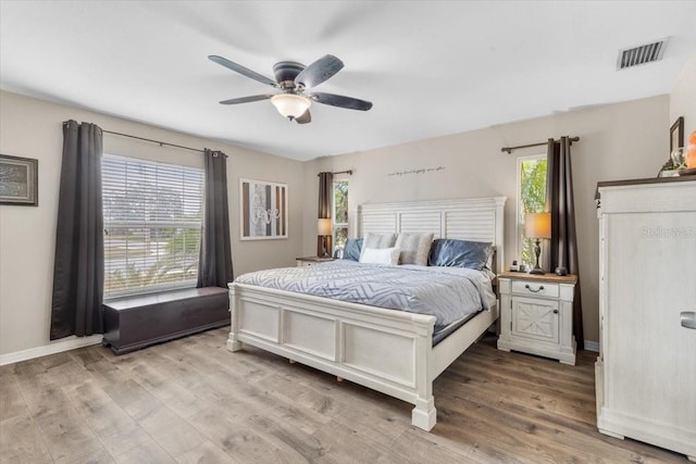 bedroom featuring multiple windows, ceiling fan, and light hardwood / wood-style flooring