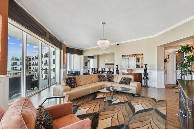 living room featuring hardwood / wood-style flooring, a chandelier, and ornamental molding