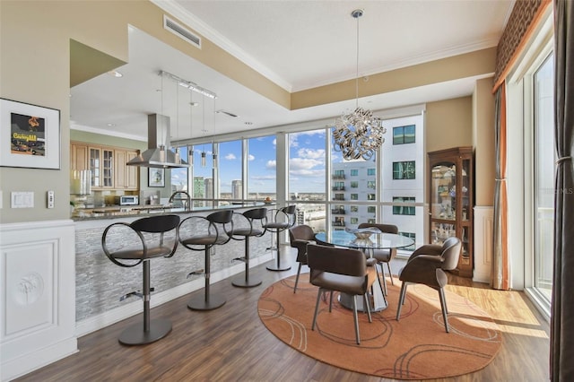 dining space with floor to ceiling windows, crown molding, a notable chandelier, and light wood-type flooring