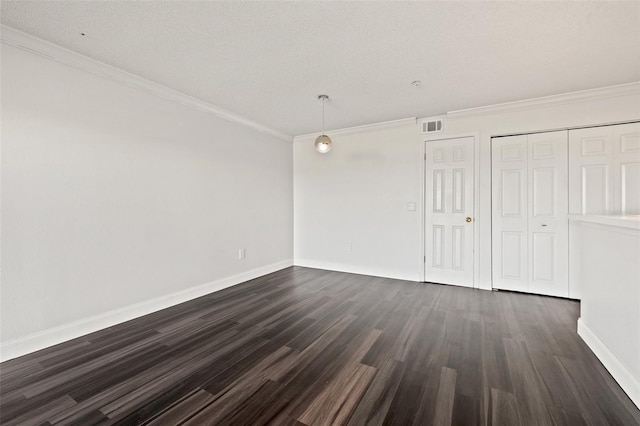 spare room with crown molding, dark wood-type flooring, and a textured ceiling