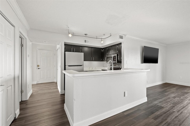 kitchen featuring an island with sink, white refrigerator, dark hardwood / wood-style floors, and crown molding