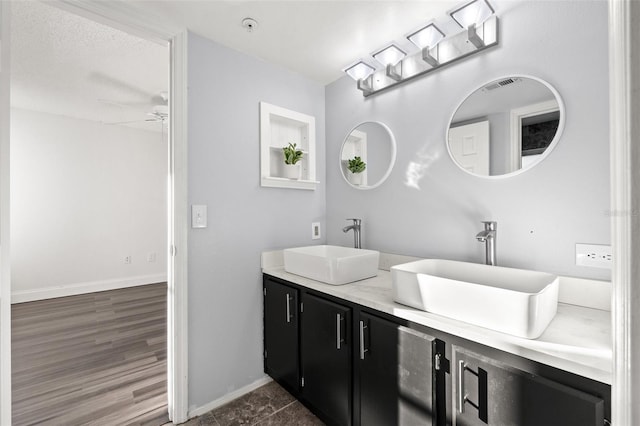 bathroom featuring ceiling fan, a textured ceiling, and vanity