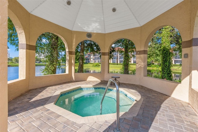 view of swimming pool with a water view and a hot tub