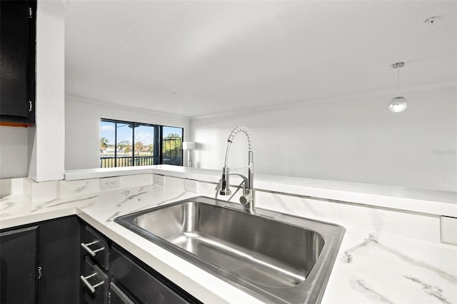 kitchen featuring sink, hanging light fixtures, and crown molding