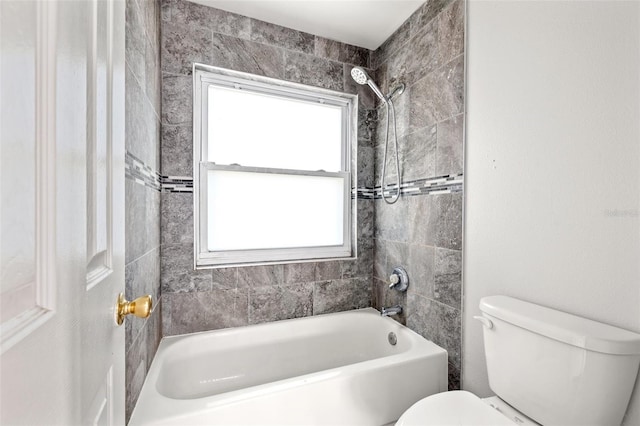 bathroom with tiled shower / bath combo, a healthy amount of sunlight, and toilet