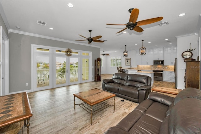 living room with ceiling fan, french doors, crown molding, and light hardwood / wood-style flooring