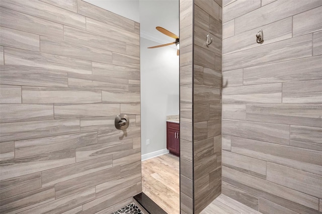 bathroom with ceiling fan and tiled shower