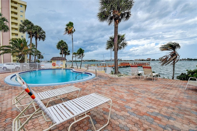 view of swimming pool with a water view and a patio