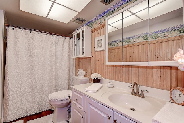 bathroom with wood walls, vanity, and toilet