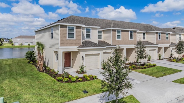 view of front of property with a front lawn, a garage, and a water view