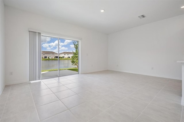 tiled empty room featuring a water view