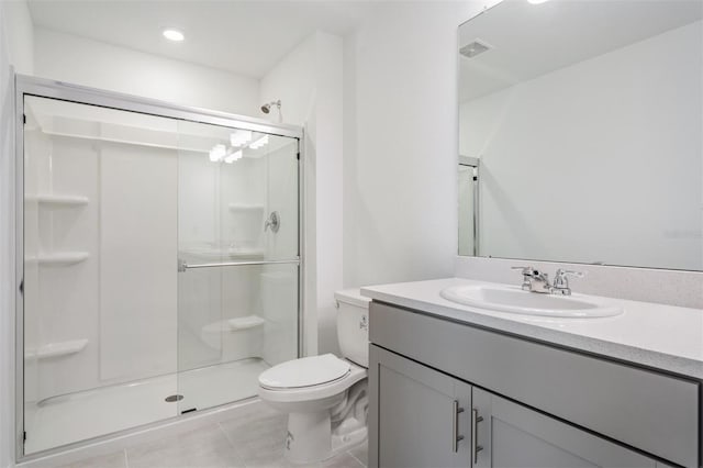 bathroom featuring vanity, tile patterned floors, a shower with shower door, and toilet