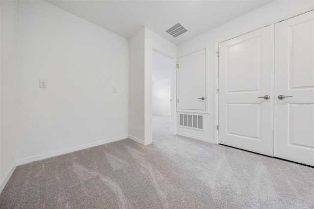 unfurnished bedroom featuring a closet and light carpet