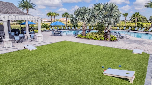 view of yard featuring a patio, a community pool, and a pergola