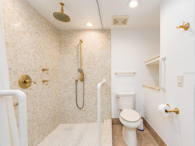 bathroom with a tile shower, tile patterned flooring, and toilet