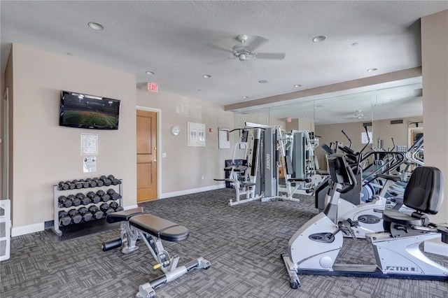 gym featuring ceiling fan, dark carpet, and a textured ceiling