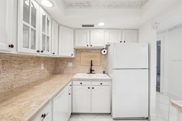 kitchen featuring white cabinets, sink, white appliances, and light tile patterned flooring