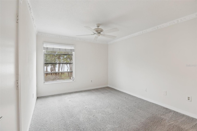 carpeted empty room featuring ceiling fan and crown molding