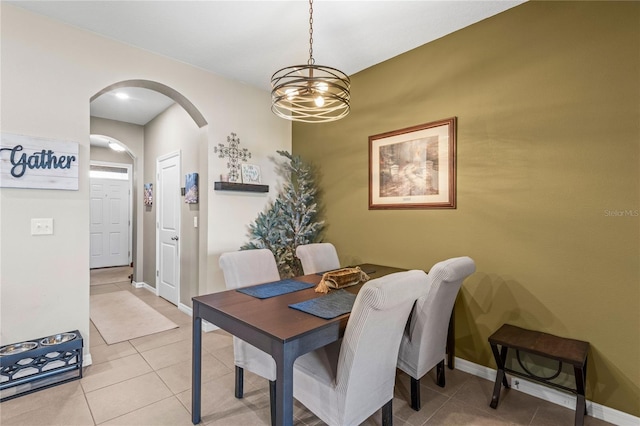 tiled dining space featuring an inviting chandelier