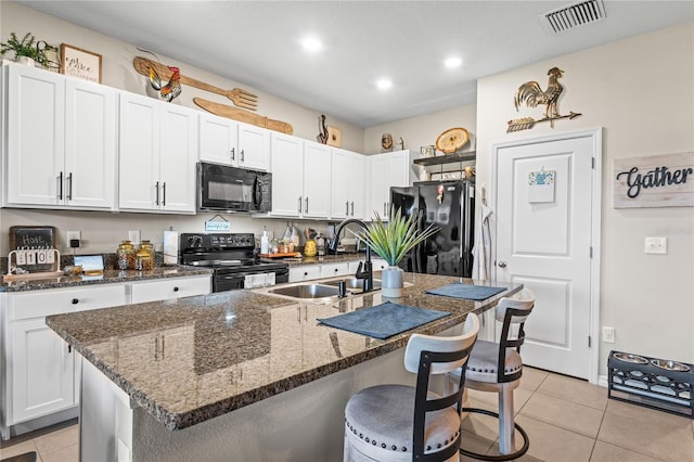 kitchen with an island with sink, white cabinetry, and black appliances