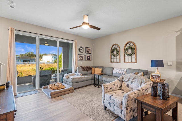 living room with light hardwood / wood-style floors and ceiling fan