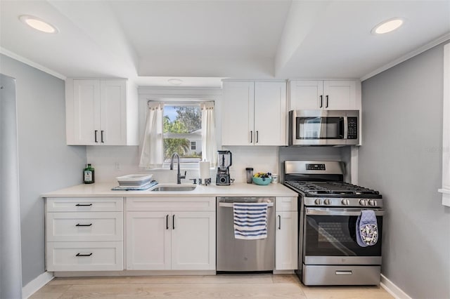 kitchen with appliances with stainless steel finishes, white cabinetry, and sink